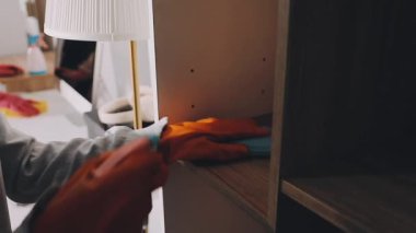 Beyaz önlüklü bir kadın mutfakta elinde beyaz bir fırça tutuyor.