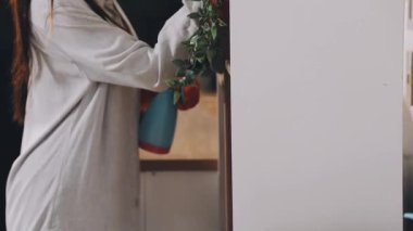 Mutfakta bir çanta dolusu yiyeceği olan bir kadın.