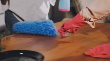 Adam evini paçavra ve fırçayla temizliyor.