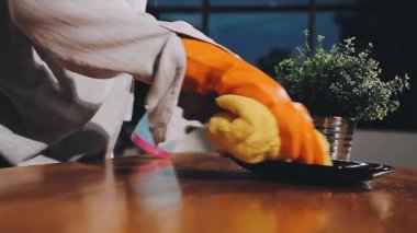 Ev hanımı mutfakta masayı temizliyor.