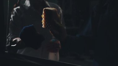 Odasında fırça olan siyah elbiseli genç adam.