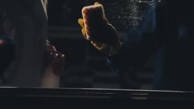 Bir bardak suyla genç bir adamın ellerini yaklaştır.