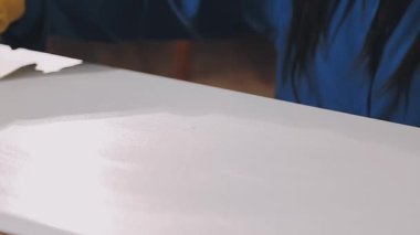 Kadının eli boyayla duvarı boyuyor