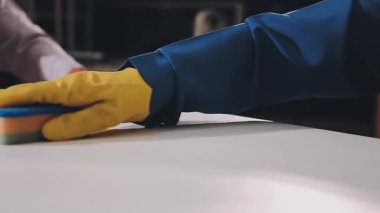 Koruyucu eldivenli işçi mutfakta bir tabak tutuyor..