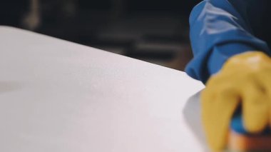 İş yerinde sarı eldivenli koruyucu maskeli işçiyi kapatın..