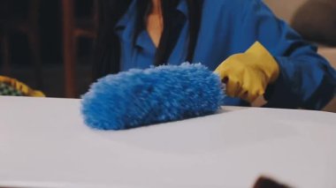 Evi temizleyen bir kadına yaklaş.