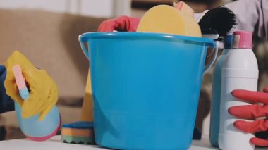 Bir adamın elleri kovayı temizliyor.