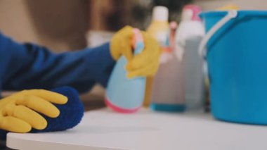 Masanın üzerinde sprey boyalı sarı eldivenlerle elinizi kapayın.