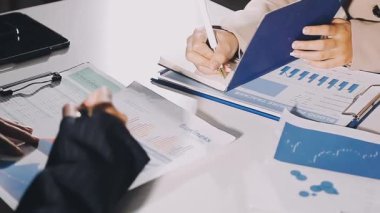 İşadamı masanın üstünde mali tablolar ve grafikler üzerinde çalışıyor..