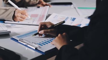 Modern ofisteki dijital tablet üzerindeki finansal verileri tartışan ve analiz eden iş adamları