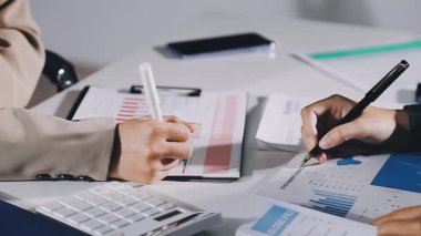 İş adamları mali grafiği analiz ediyor ve ofiste planı, iş ve finans konularında takım çalışmasını tartışıyorlar..