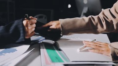 İş adamları ofiste dijital tablet verilerini tartışıyor ve analiz ediyorlar.