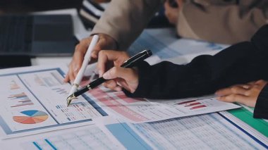 Ofisteki dizüstü bilgisayardaki mali raporları analiz eden iş adamları.