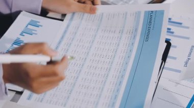 Genç işadamı kalemle grafiği analiz ediyor