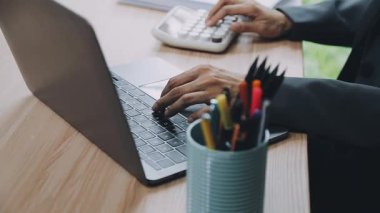 Genç işadamı ofiste dizüstü bilgisayarla çalışıyor..