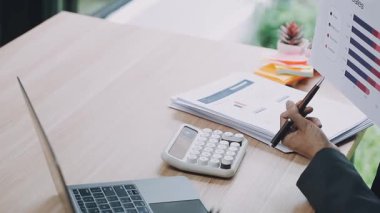 İş adamı ofisteki defterde hesap makinesi ve yazı kullanıyor..