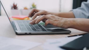 Merkez ofisteki klavyede dizüstü bilgisayarda yazan adam.