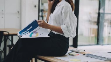 Genç Asyalı iş kadını ofisinde çalışıyor.