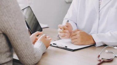 Tıp üniformalı kadın doktor hastanede otururken bir şey tartışıyor..