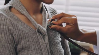 Genç doktor hastanın nabzını kontrol ediyor.