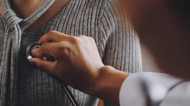 Genç bayan doktor nabzını steteskopla kontrol ediyor..