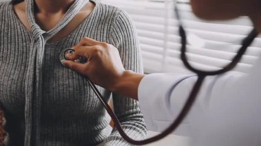 Doktor hastanede steteskoplu bir hastayı muayene ediyor.