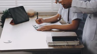 Klinikteki masada tablet bilgisayarı olan doktor.