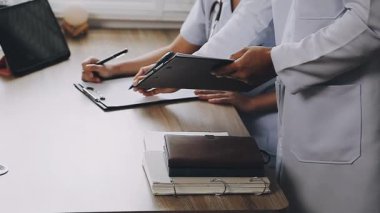 Klinikte dijital tablet ve tıbbi raporlarla çalışan bir doktor. Sağlık ve Tıp Hizmetleri kavramı.