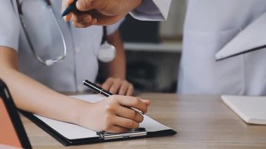 Kadın doktor deftere yazıyor.
