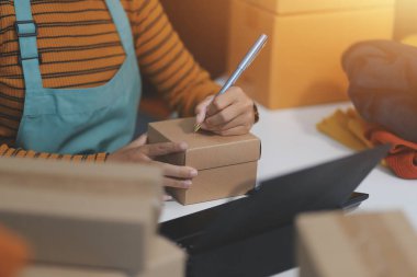 Vlogger, blog yazarı, küçük KOBİ iş kadını güzel bir kadın cep telefonuyla kıyafetleri satıyor canlı yayın satışı yapıyor, ana ofiste ürün sunumu detaylarını gösteriyor, girişimci ekommerce