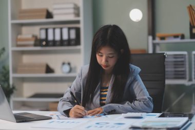 Ofiste dizüstü bilgisayarda çalışan neşeli iş kadını, iş yerinde resmi takım elbiseli Asyalı mutlu iş kadını. Çekici bayan ofis çalışanı gülümsemesi.
