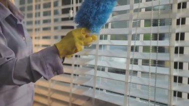 Pencereyi temizleyen adam bir evde bez parçasıyla.