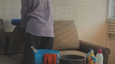 Adam evi fırça ve paçavrayla temizliyor.