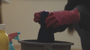 Elinde fırça ve fırça olan siyah lastik eldivenli bir adam.