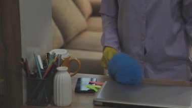 Temizlik konsepti Adam ofisi dizüstü bilgisayar ve spreyle temizliyor.