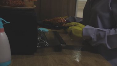 Mutfakla masayı temizleyen kadın.