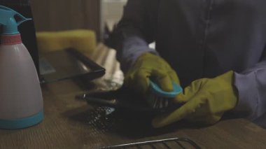 Mutfak masasını bir bez parçasıyla temizliyorum.