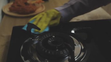 Mutfakta siyah önlüklü bir adam var.