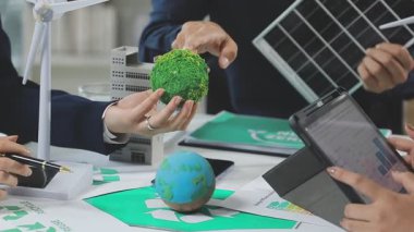 Güneş enerjisi modelini elinde yeşil enerjiyle tutan iş adamlarına yakın çekim. sürdürülebilir geliştirme kavramı
