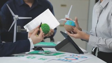 İş yerinde güneş panelleri ve yeşil rüzgar türbini olan genç bir kadın.