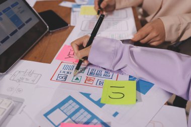 Mobil uygulama arayüzü kablo dizaynı hakkında modern ofisteki müşteri breif ve renk kodu ile fikir alışverişinde bulunan uu geliştirici ve ui tasarımcısını kapat. Yaratıcı dijital geliştirme ajansı.