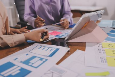 Mobil uygulama arayüzü kablo dizaynı hakkında modern ofisteki müşteri breif ve renk kodu ile fikir alışverişinde bulunan uu geliştirici ve ui tasarımcısını kapat. Yaratıcı dijital geliştirme ajansı.