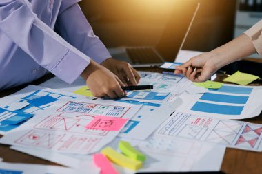 Mobil uygulama arayüzü kablo dizaynı hakkında modern ofisteki müşteri breif ve renk kodu ile fikir alışverişinde bulunan uu geliştirici ve ui tasarımcısını kapat. Yaratıcı dijital geliştirme ajansı.