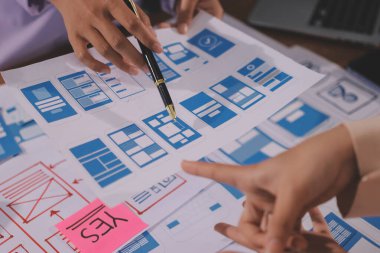 Mobil uygulama arayüzü kablo dizaynı hakkında modern ofisteki müşteri breif ve renk kodu ile fikir alışverişinde bulunan uu geliştirici ve ui tasarımcısını kapat. Yaratıcı dijital geliştirme ajansı.