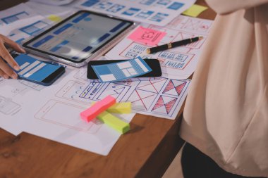 Mobil uygulama arayüzü kablo dizaynı hakkında modern ofisteki müşteri breif ve renk kodu ile fikir alışverişinde bulunan uu geliştirici ve ui tasarımcısını kapat. Yaratıcı dijital geliştirme ajansı.