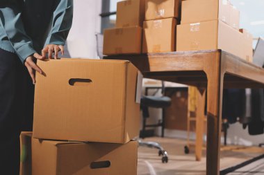 Girişim KOBİ küçük işletme girişimcisi önlük giyen Asyalı kadın dizüstü bilgisayar ve kutu kullanarak çevrimiçi müşterilere, çevrimiçi sme iş fikirlerine satış hazırlamak için siparişleri alır ve gözden geçirir.