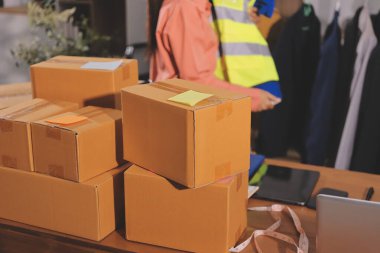 Girişim KOBİ küçük işletme girişimcisi önlük giyen Asyalı kadın dizüstü bilgisayar ve kutu kullanarak çevrimiçi müşterilere, çevrimiçi sme iş fikirlerine satış hazırlamak için siparişleri alır ve gözden geçirir.