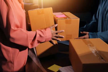 Girişim KOBİ küçük işletme girişimcisi önlük giyen Asyalı kadın dizüstü bilgisayar ve kutu kullanarak çevrimiçi müşterilere, çevrimiçi sme iş fikirlerine satış hazırlamak için siparişleri alır ve gözden geçirir.