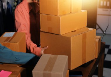 Girişim KOBİ küçük işletme girişimcisi önlük giyen Asyalı kadın dizüstü bilgisayar ve kutu kullanarak çevrimiçi müşterilere, çevrimiçi sme iş fikirlerine satış hazırlamak için siparişleri alır ve gözden geçirir.