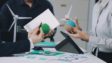 Rüzgar türbini modelli Asyalı kadın güneş paneli tutuyor ve tablet kullanıyor..